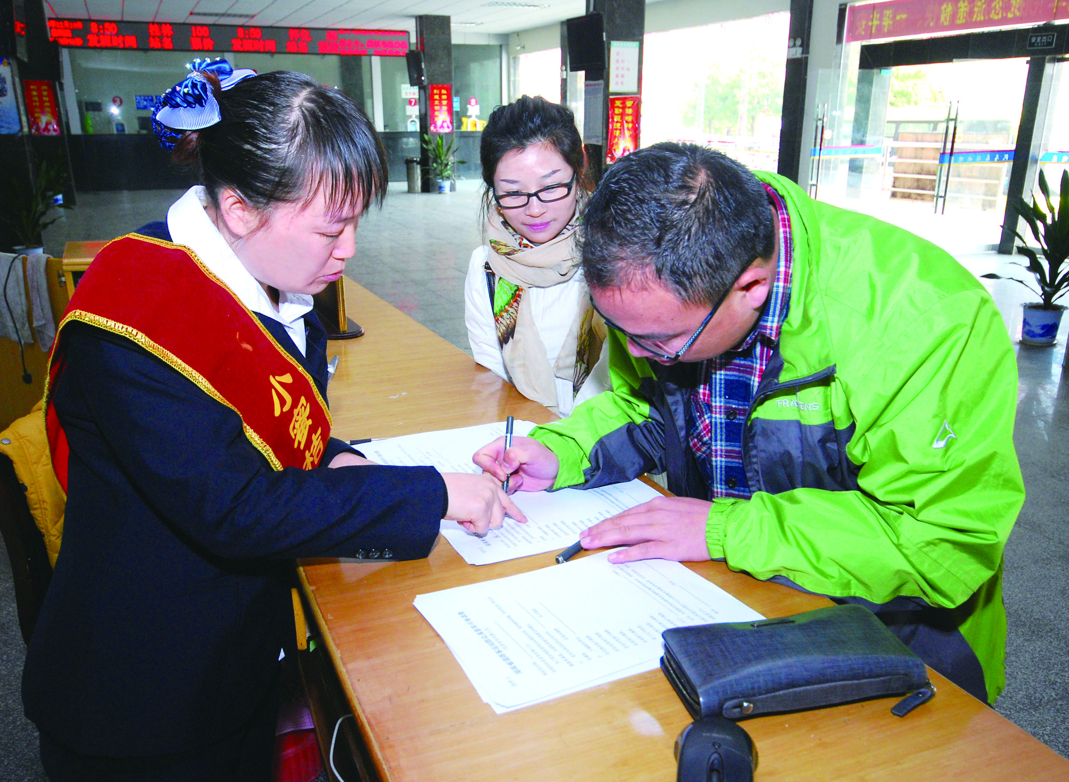 圖為洞口汽車總站站務(wù)人員在熱心為旅客服務(wù)。